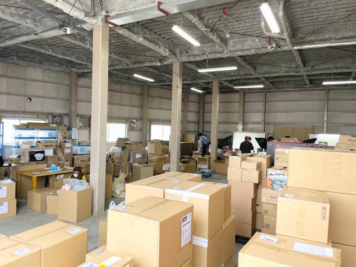 名古屋の物流倉庫で、スタッフが商品の検品と梱包を行っている様子